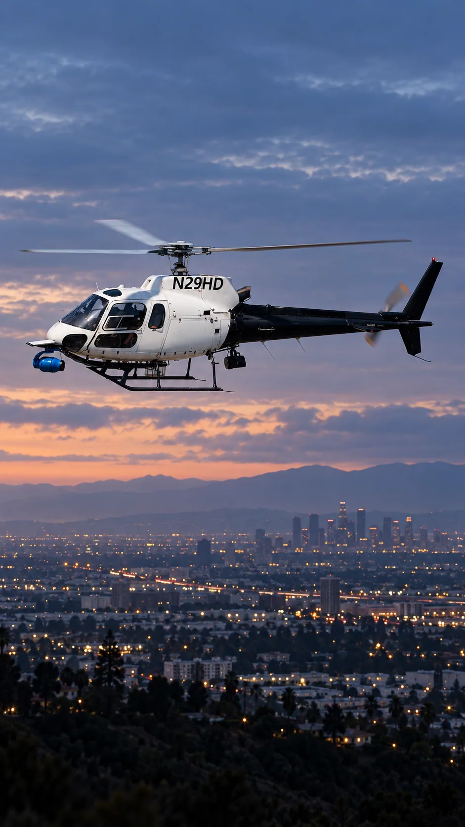 Illustration of AIR7 (backup) · N29HD, an Airbus AS350 B2, over the Los Angeles basin at dusk.