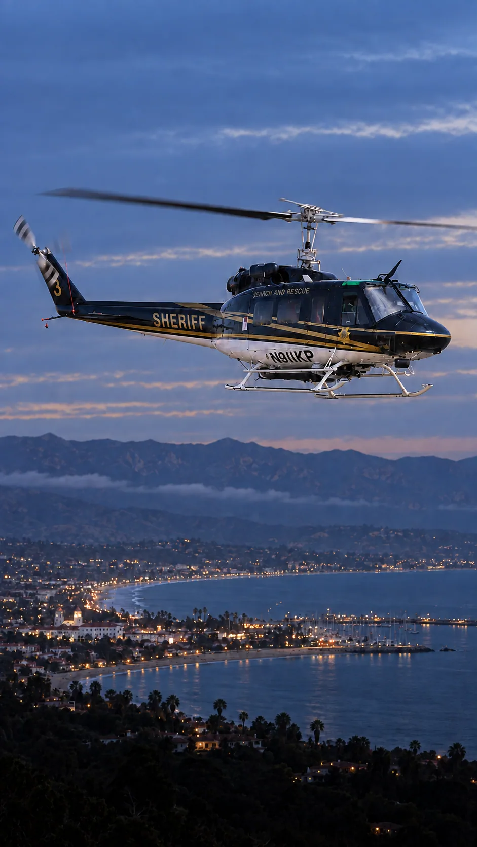 Illustration of N911KP, a Bell UH-1H Huey of the Santa Barbara County Sheriff — over the Santa Barbara County coastline.